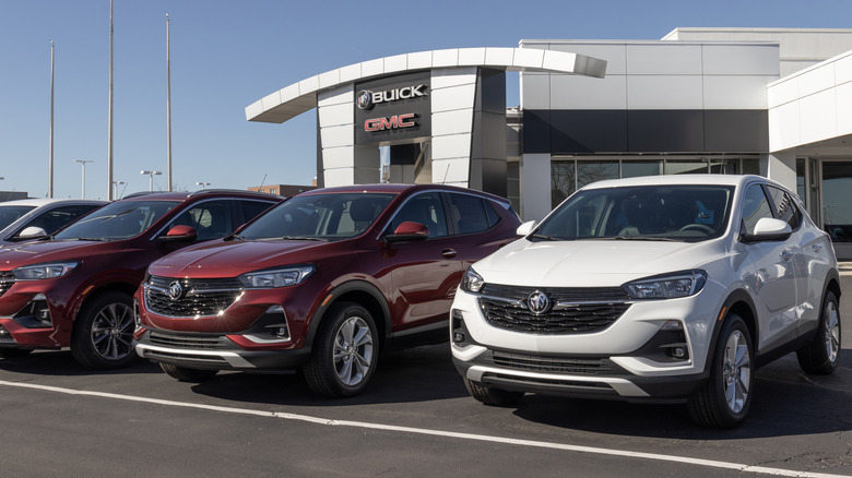 Several examples of the Buick Encore at a dealership, two red and one white