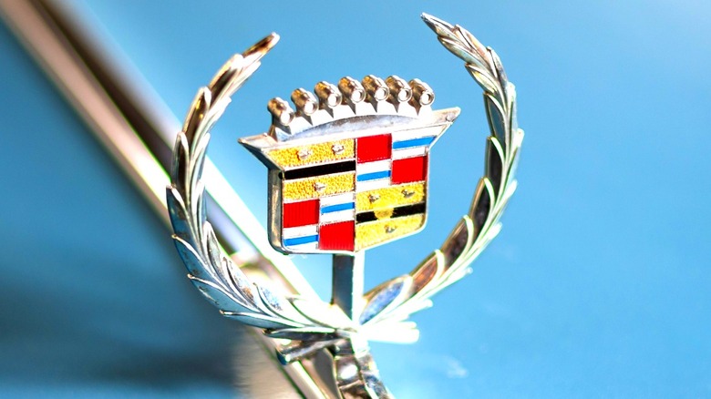 Vintage Cadillac hood emblem on light blue car