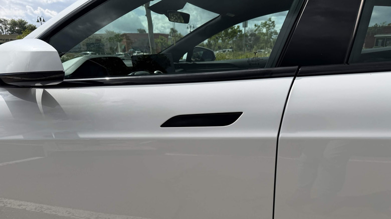 Tesla Model Y, white with hidden black door handles, driver's door close-up
