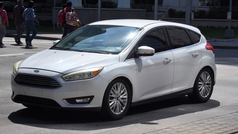 A white Ford Focus on a street.