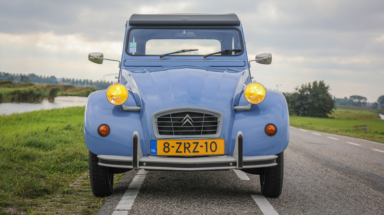 Front view of a blue Citroen 2CV with yellow headlights, Dutch license plates