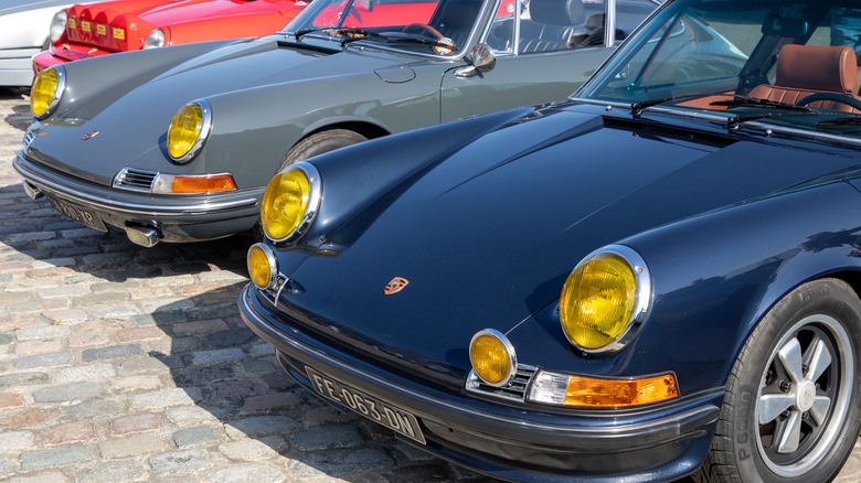 A duo of classic Porsche 911s with yellow headlights