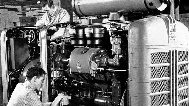 Technicians working on a General Motors diesel engine