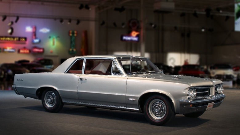 Front 3/4 view of 1964 gray Pontiac GTO in museum setting