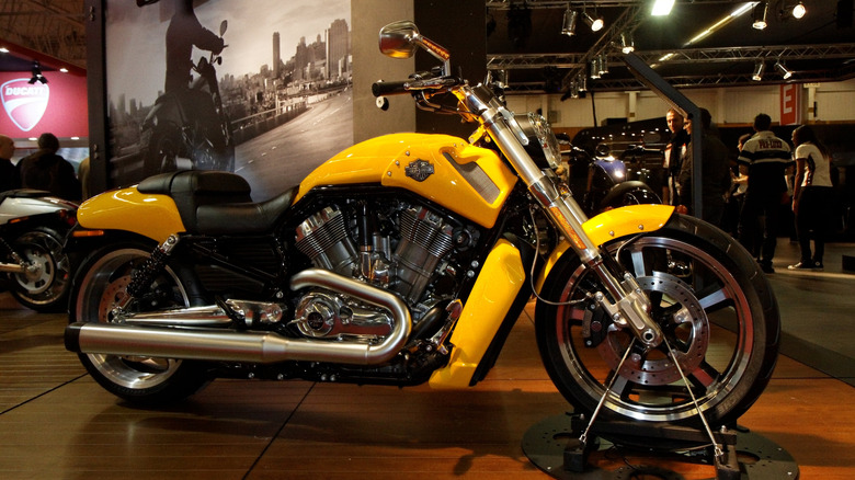 A yellow Harley-Davidson V-Rod Muscle motorcycle at a bike show, side view