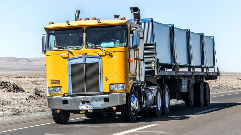 Kenworth K100 cabover pulling a trailer on an interurban freeway