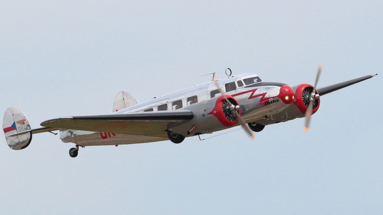 Red and chrome Lockheed Model 10 flying in the air