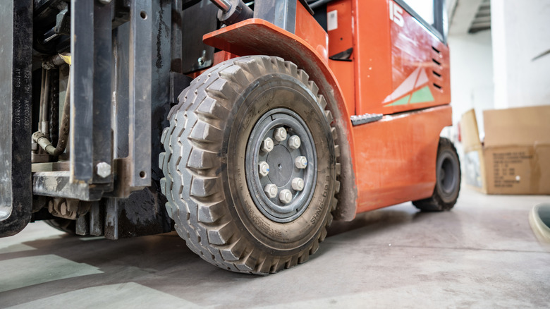 The close-up of the front wheel and tire of a forklift