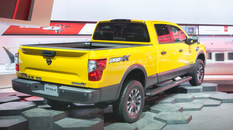 Right rear view of yellow 2016 Nissan Titan XD truck at an auto show