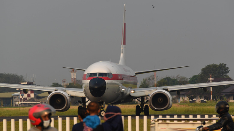 parked aircraft with aluminium fuselage and black nose