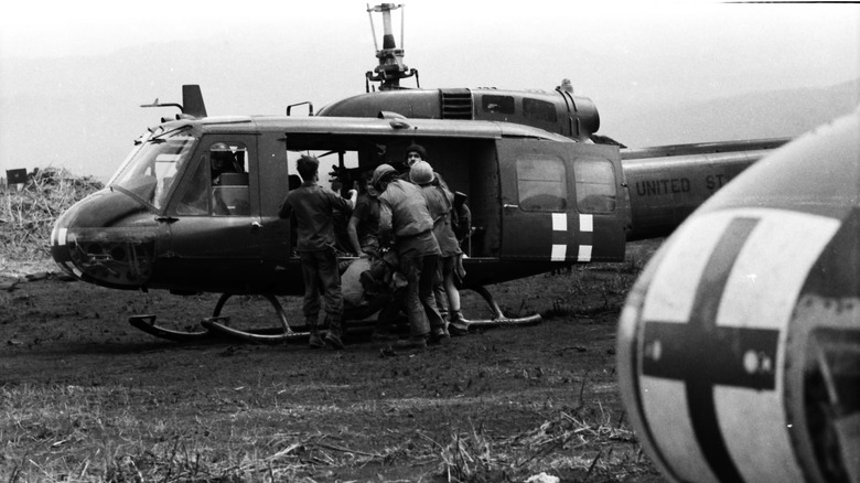 Wounded soldier being loaded into a medivac helicopter on the battlefield