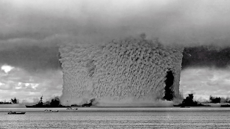 The blast from the Baker nuclear bomb test during Operation Crossroads at Bikini Atoll on July 25, 1946, showing naval warships impacted by the explosion.