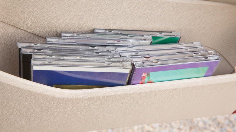 Loads of jewel-cased CDs crammed into a car door.
