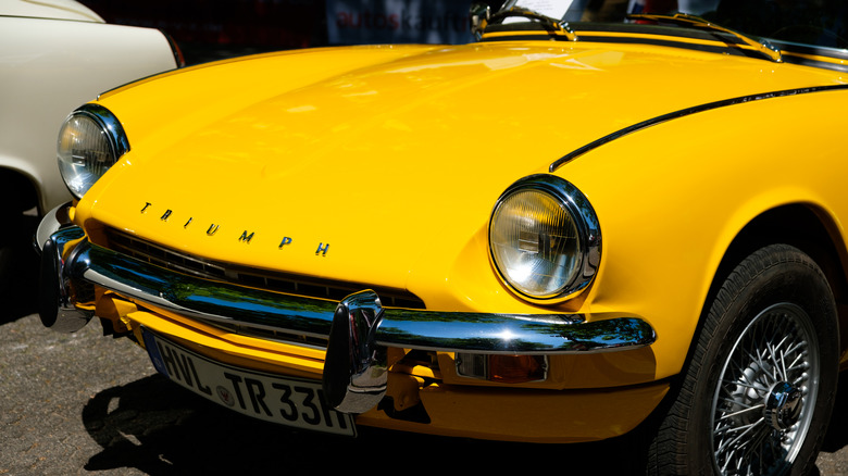 Triumph name on hood of yellow sports car