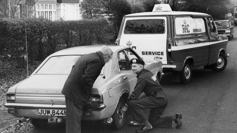 An RAC service mechanic fixing a broken down Ford Cortina, England.