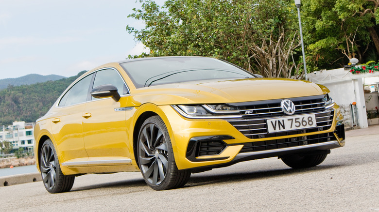 A yellow Volkswagen Arteon parked up by the side of the road