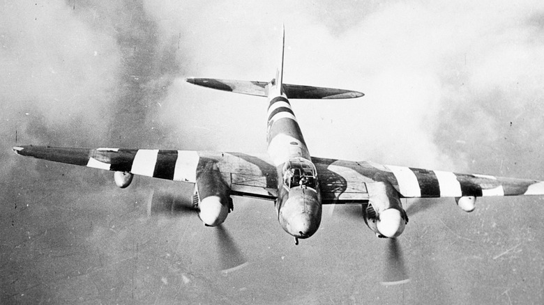 A plane sporting invasion stripes barrels towards the beachhead on D-Day.