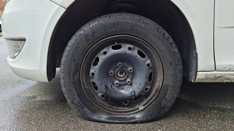 Close up of a really flat tire on a white vehicle