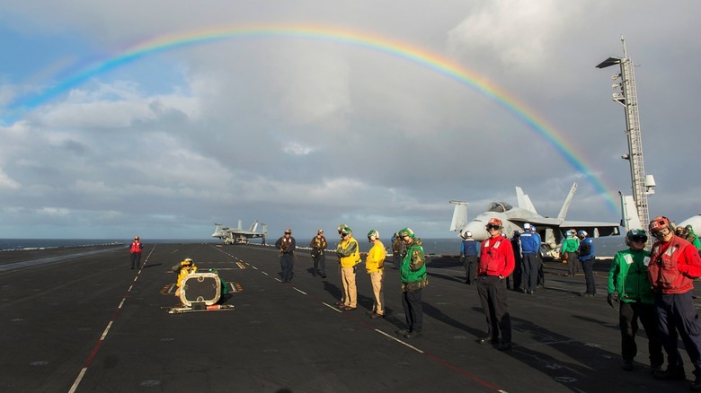 Flight deck crew standing around with a rainbow in the background