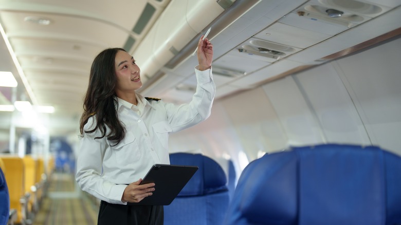 flight attendant holding tablet and stylus