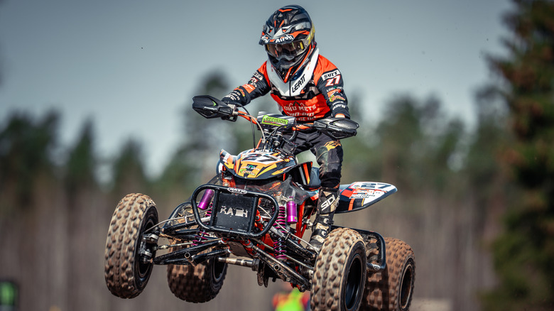 person wearing helmet and gloves riding an atv