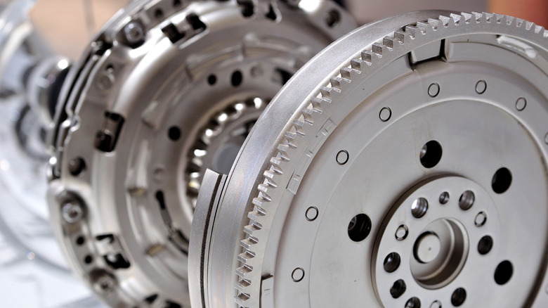 Car flywheel with clutch in background, selective focus picture targeting flywheel