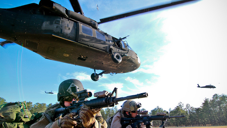 Soldiers with the 227th Air Support Operations Squadron provide cover after a tactical air insertion with an Army UH-60 Black Hawk helicopter.
