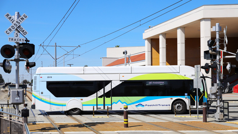 A Foothill Transit bus crossing railroad tracks in California.