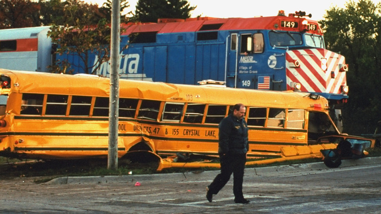 A crumpled school bus hit by a locomotive.