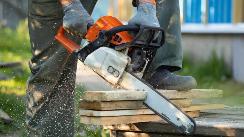 A person cutting through wood with a chainsaw