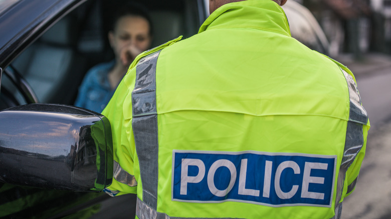 Police officer talking to woman in driver's seat