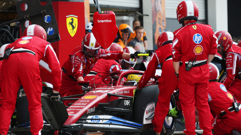 Ferrari mechanics work on Lewis Hamilton's car in pits