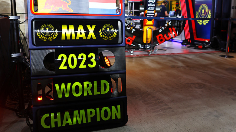 Pit board being used as a celebratory banner in front of Red Bull garage, reading 