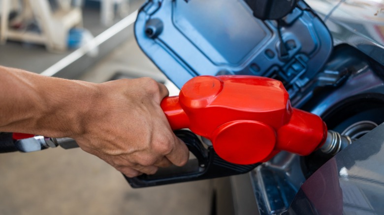 Close up shot of a person refueling a car at the gas station