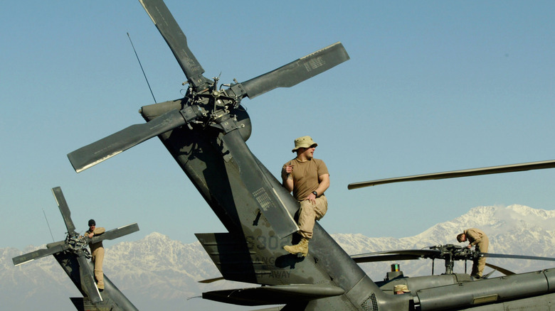 Detail view of tail rotors on two AH-64 Apache attack helicopters being inspected by US Air Force personnel