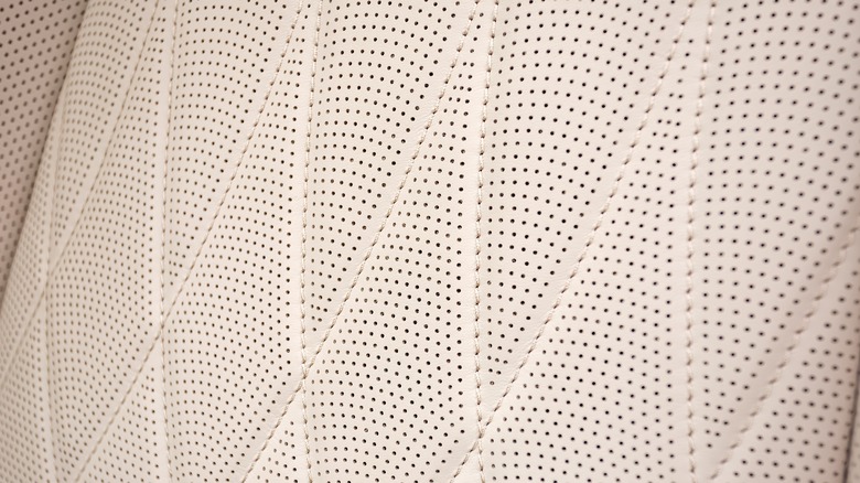 Close-up view of a car's perforated leather upholstery with stitching details