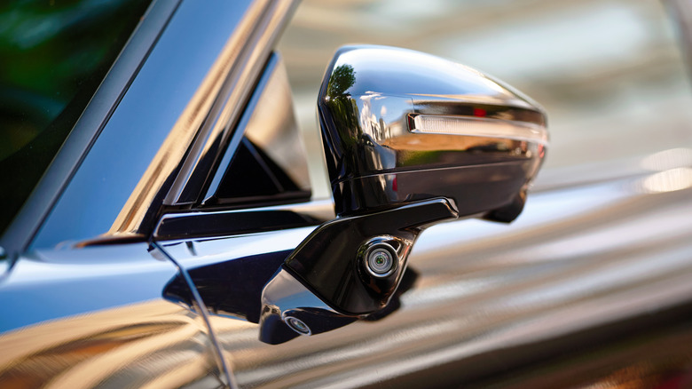 A vehicle side mirror with a blind-spot monitoring system utilizing cameras