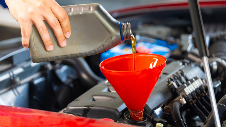 Adding motor oil to engine
