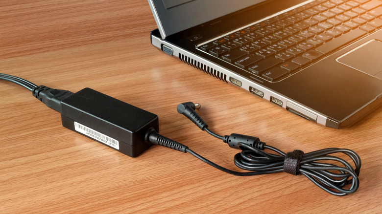 Laptop with charger on a wooden table