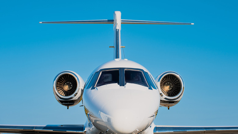 Tail, fuselage and jet engines of a small private jet against the blue sky
