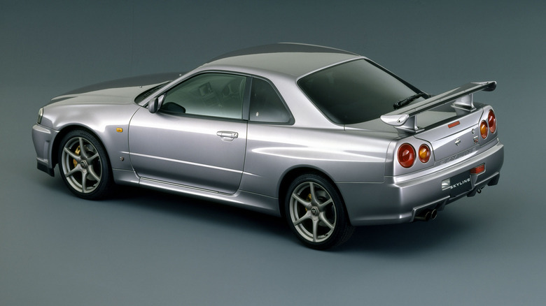 1999 Nissan Skyline GT-R V-Spec, a typical 2-door sports car, rear-left 3/4 view, gray background