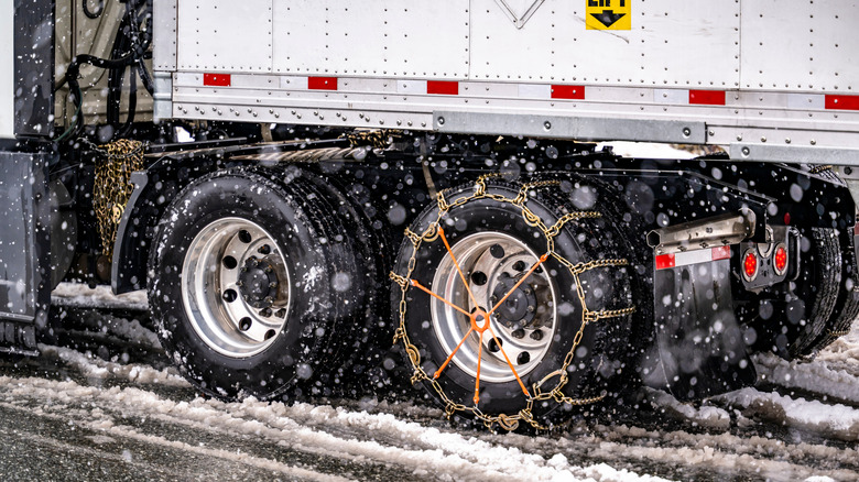 A big rig semi truck with a snow chain installed