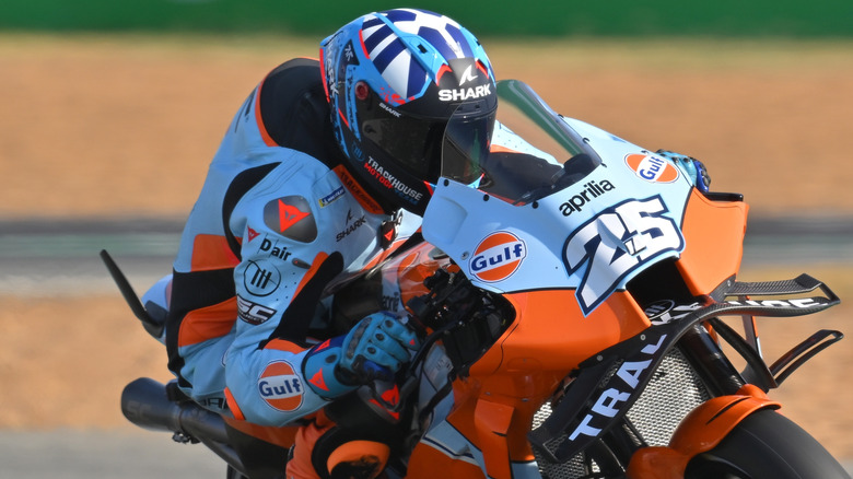 A MotoGP racer with a visible  hump on the back of his jacket