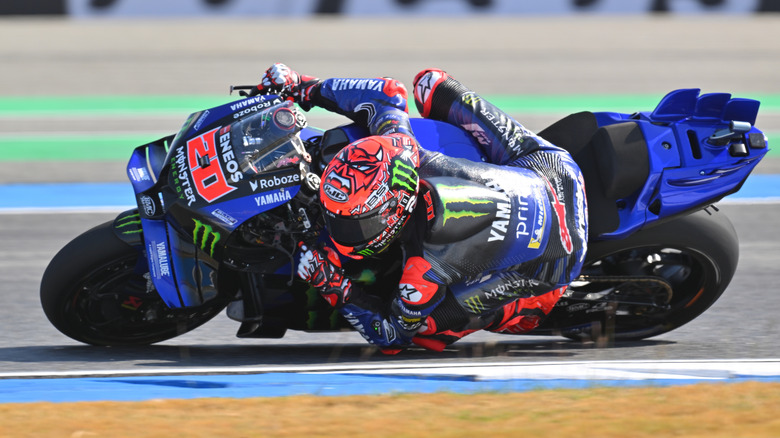 A MotoGP writer gets close to the ground on a turn
