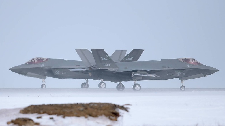 Two Norwegian F-35 fighters on a frozen runway
