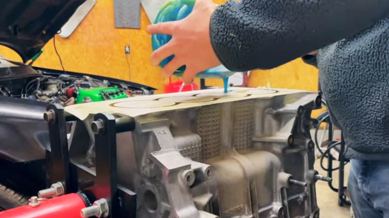 Mechanic fills a car engine block with epoxy