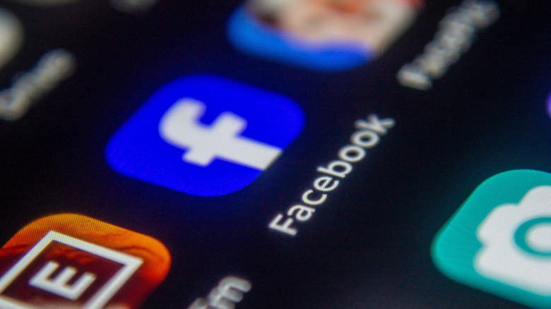 Close-up of a smartphone screen displaying various mobile application icons including the Facebook app