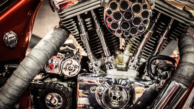 A close up of a motocycle engine with a wrapped exhaust