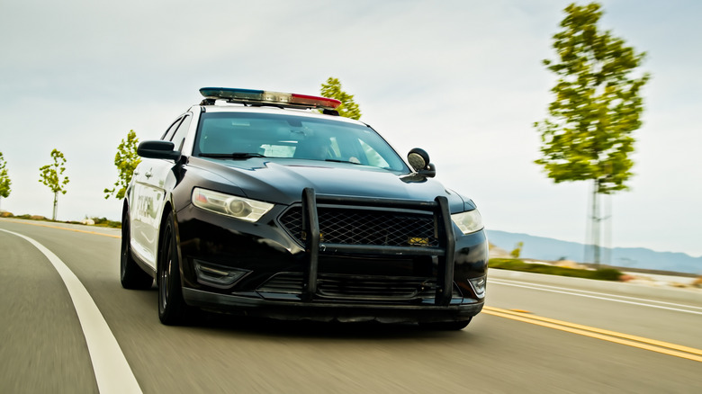 A police car equipped with a bull bar attachment on the front bumper.