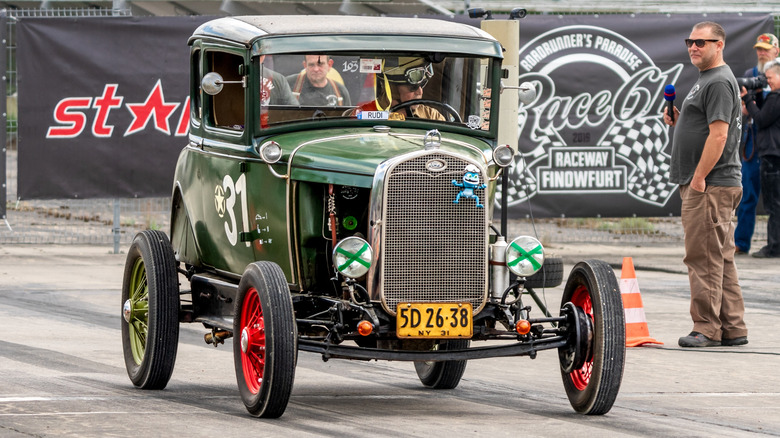 A classic car with X tape on headlights